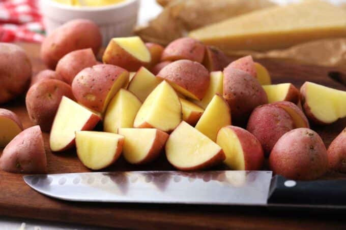 chopped baby red potatoes on a cutting board