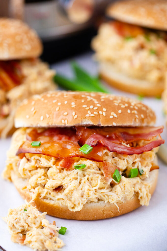 Instant Pot crack chicken served on buns with crispy bacon.