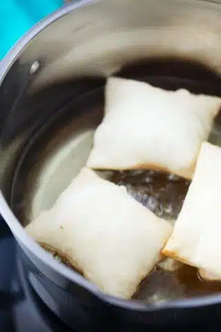 frying sopapillas in a pot with oil