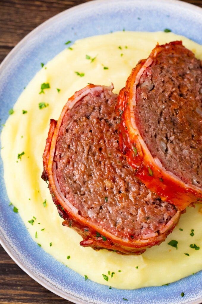 Juicy bacon wrapped meatloaf served with mashed potatoes.