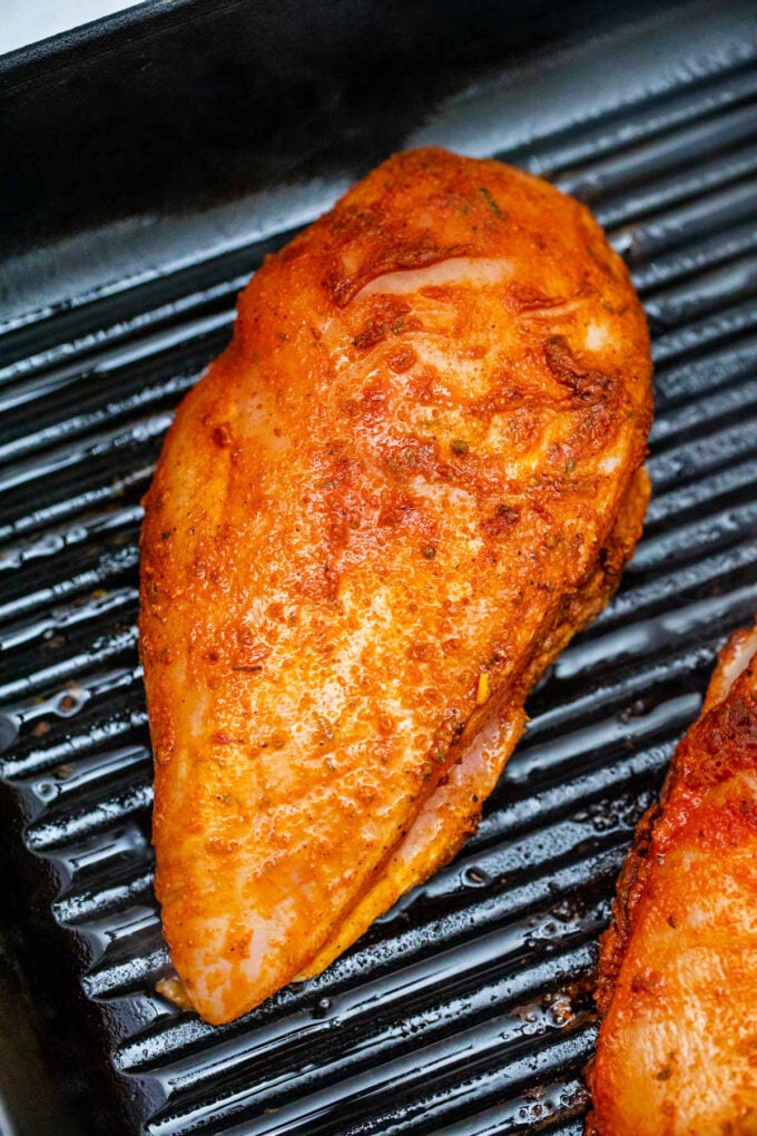 Cooking chicken breast on a grill pan.