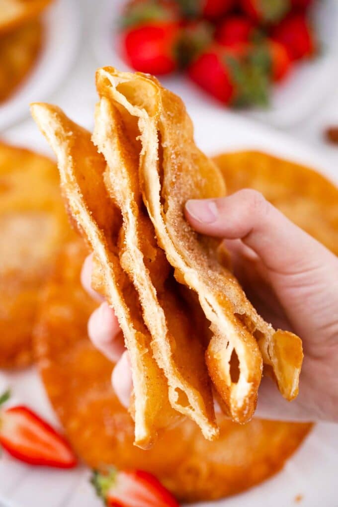 a hand holding a stack of homemade sliced bunuelos 