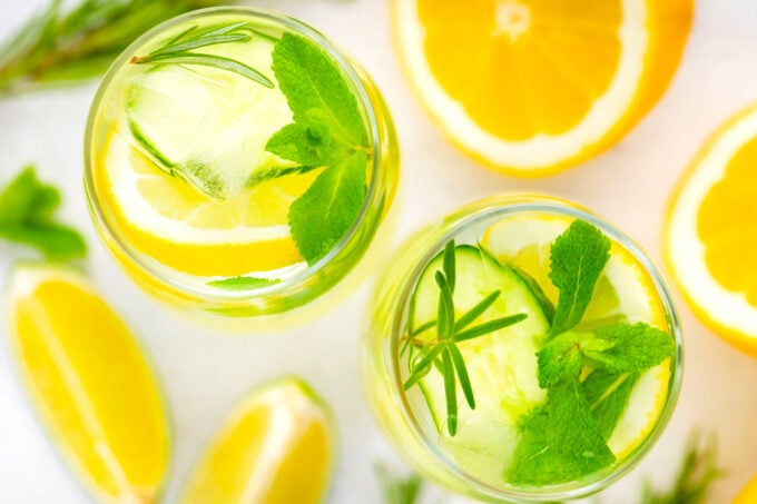 Overhead shot of glasses filled with cucumber rosemary detox water.
