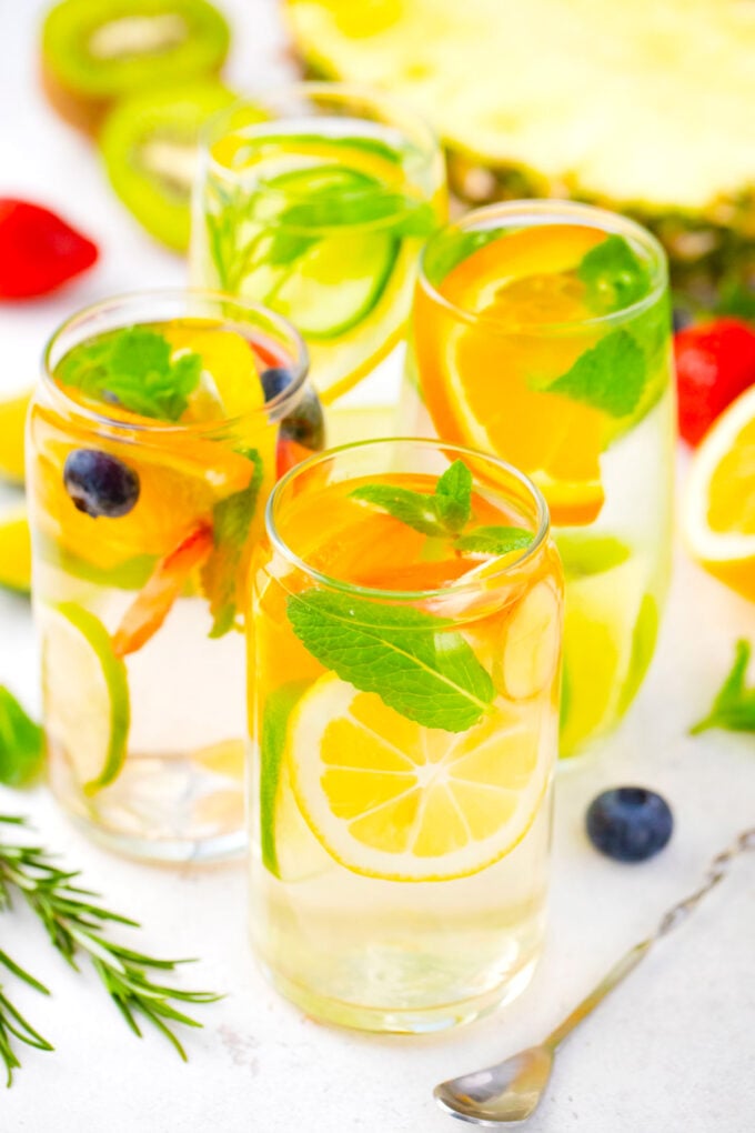Four different glasses with homemade detox water.