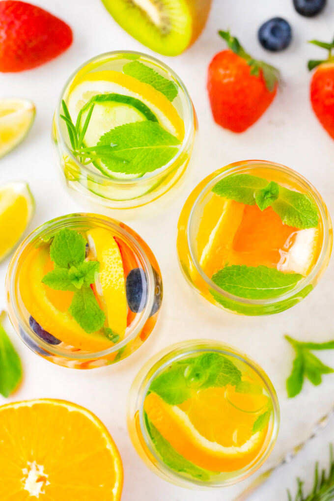 Overhead shot of four varieties of homemade detox water.