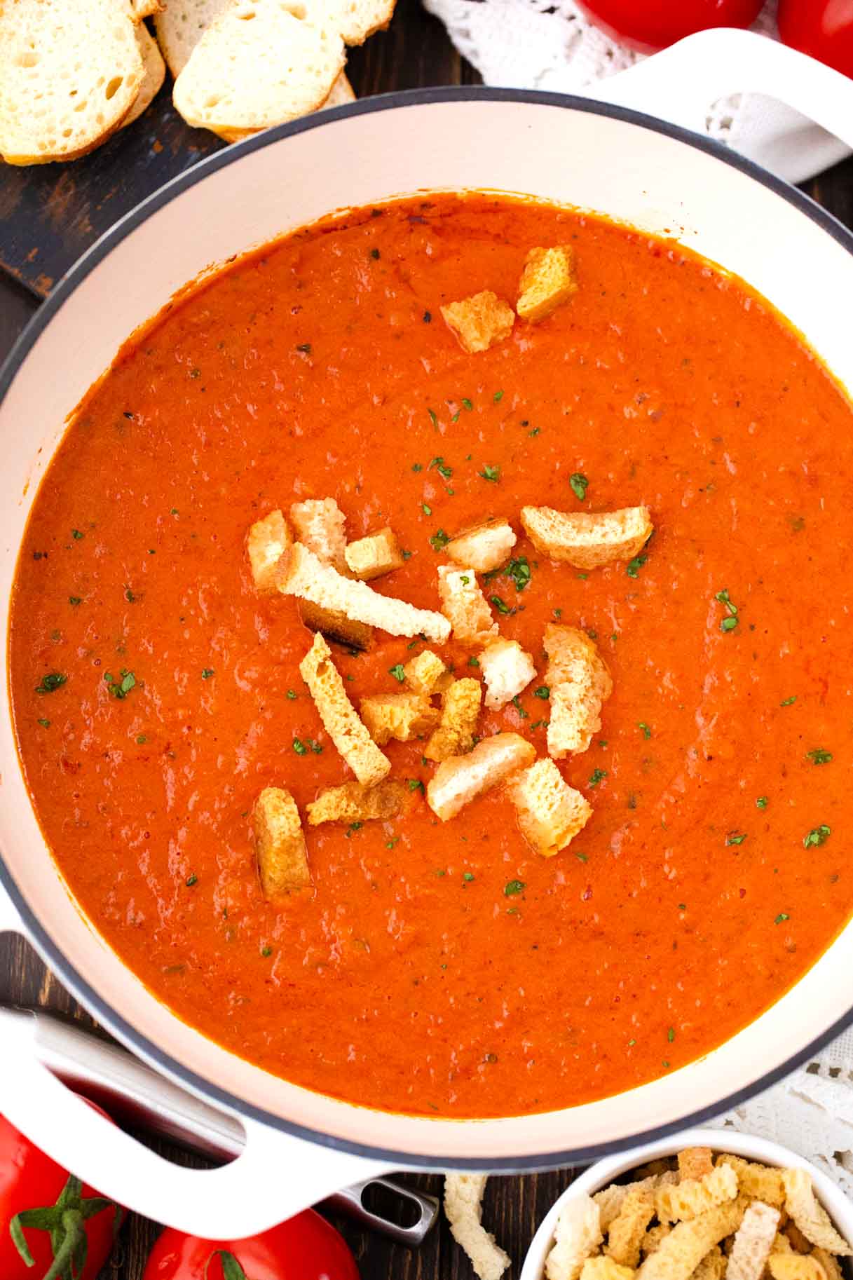 overhead shot of a pot of homemade panera bread creamy tomato soup topped with croutons