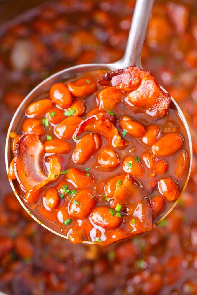 A ladle of instant pot baked beans with bacon.