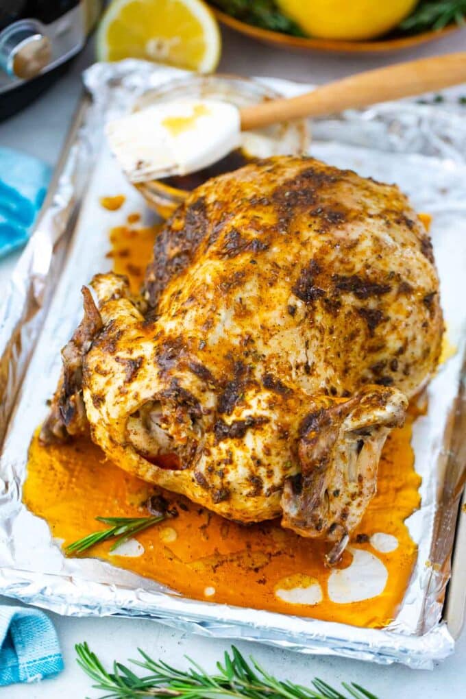 brushing instant pot whole chicken with paprika sauce before roasting