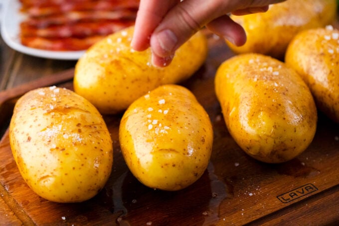 Seasoning with salt whole potatoes that have been rubbed in oil.