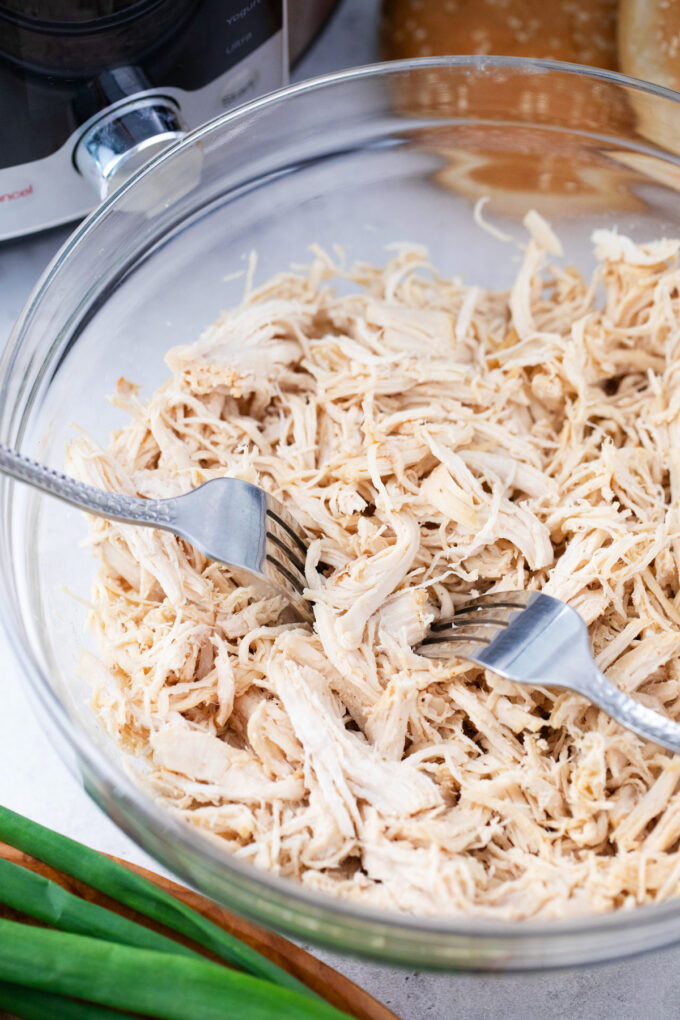 Shredding chicken in a bowl.