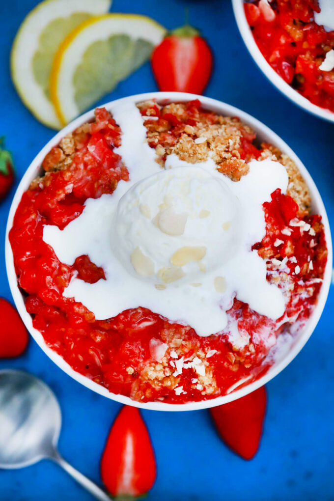 Overhead shot of strawberry crisp topped with vanilla ice cream.