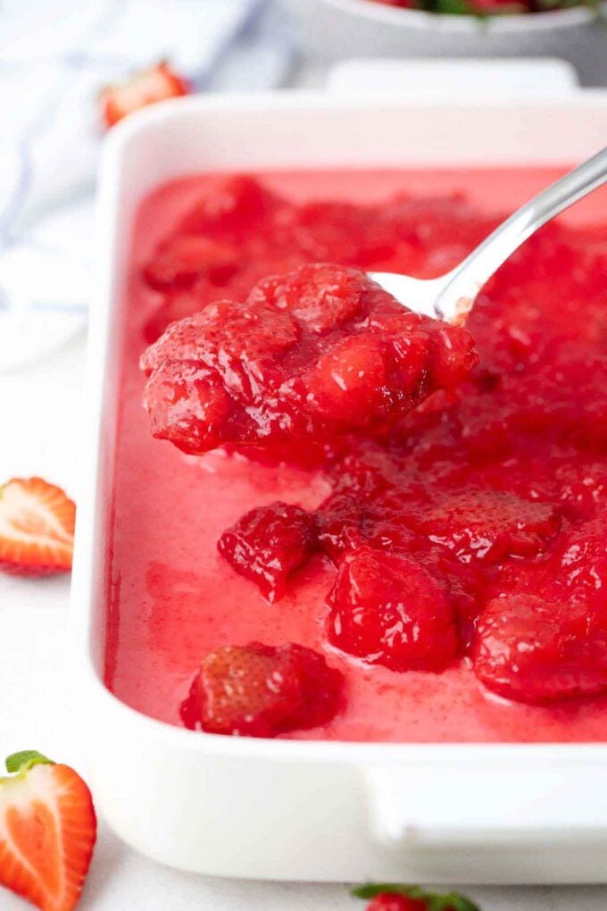 adding strawberry filling on top of strawberry poke cake