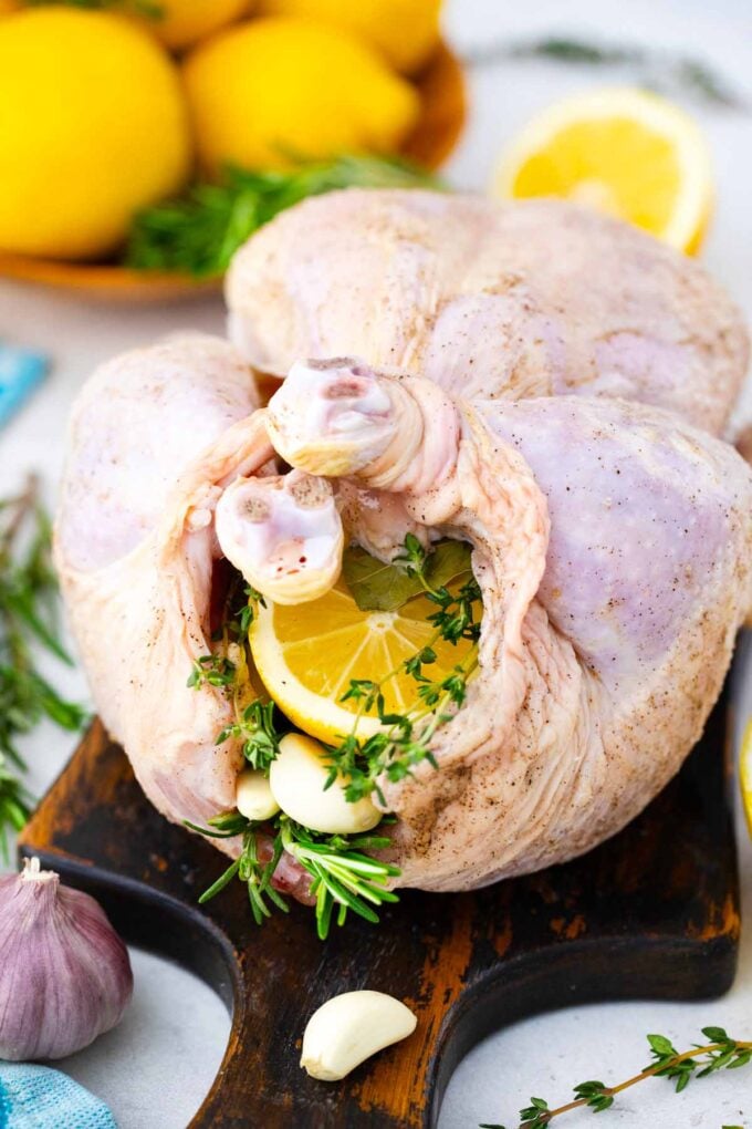 stuffing raw chicken with lemon and herbs