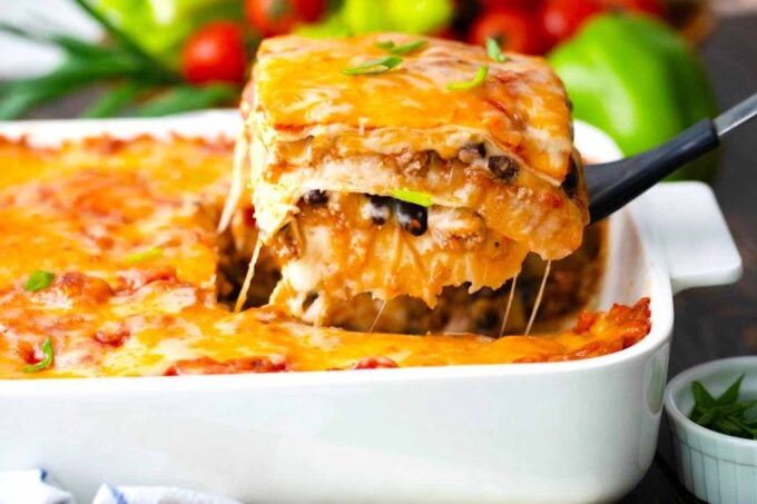 A slice of taco lasagna on a serving spatula.