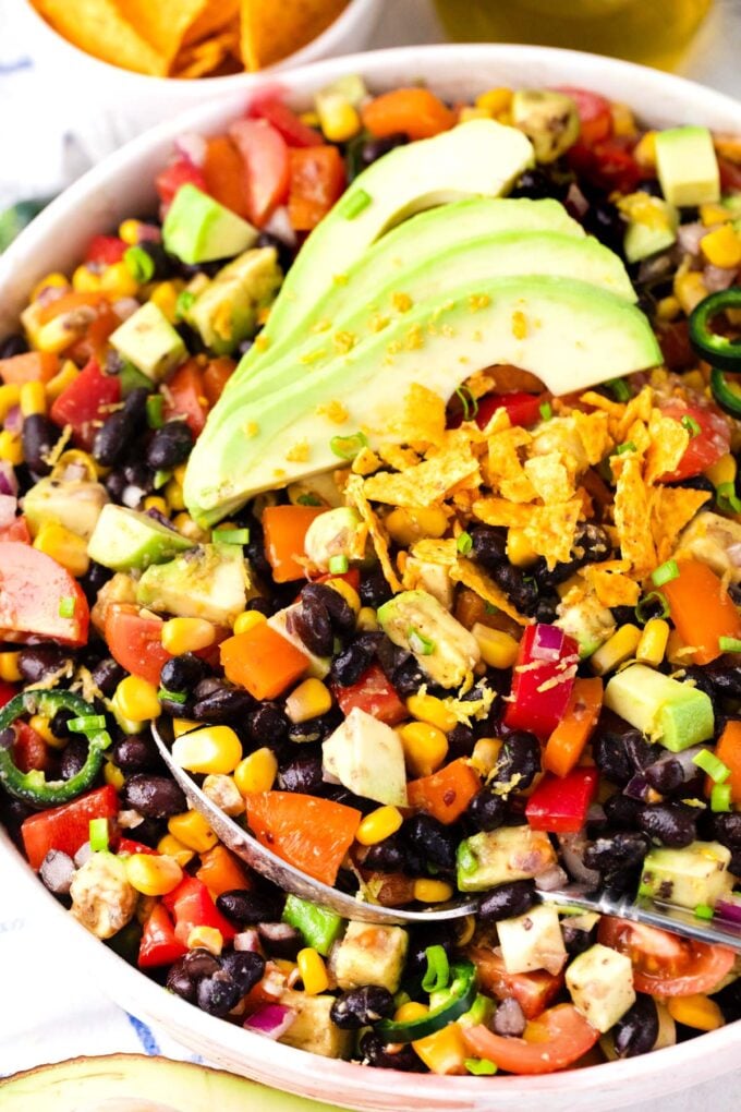 Overhead shot of Mexican black bean salad with corn chips and avocado.