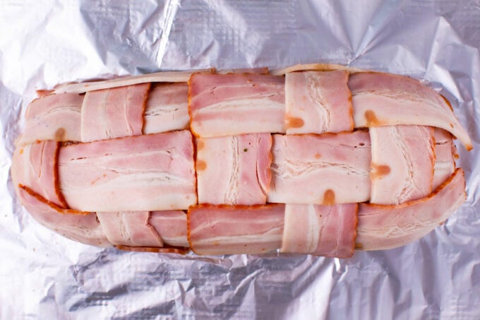 Overhead shot of bacon wrapped meatloaf on a baking tray.