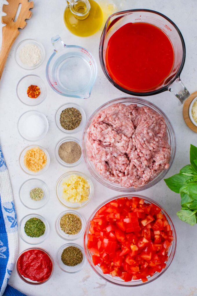 Overhead shot of Instant Pot spaghetti sauce ingredients in bowls on a table.