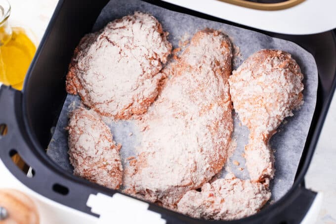 Air frying chicken pieces.