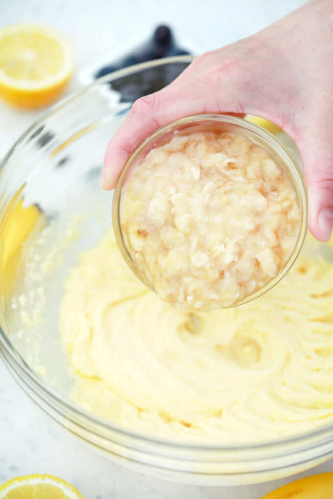 Adding mashed bananas to a wet ingredients.