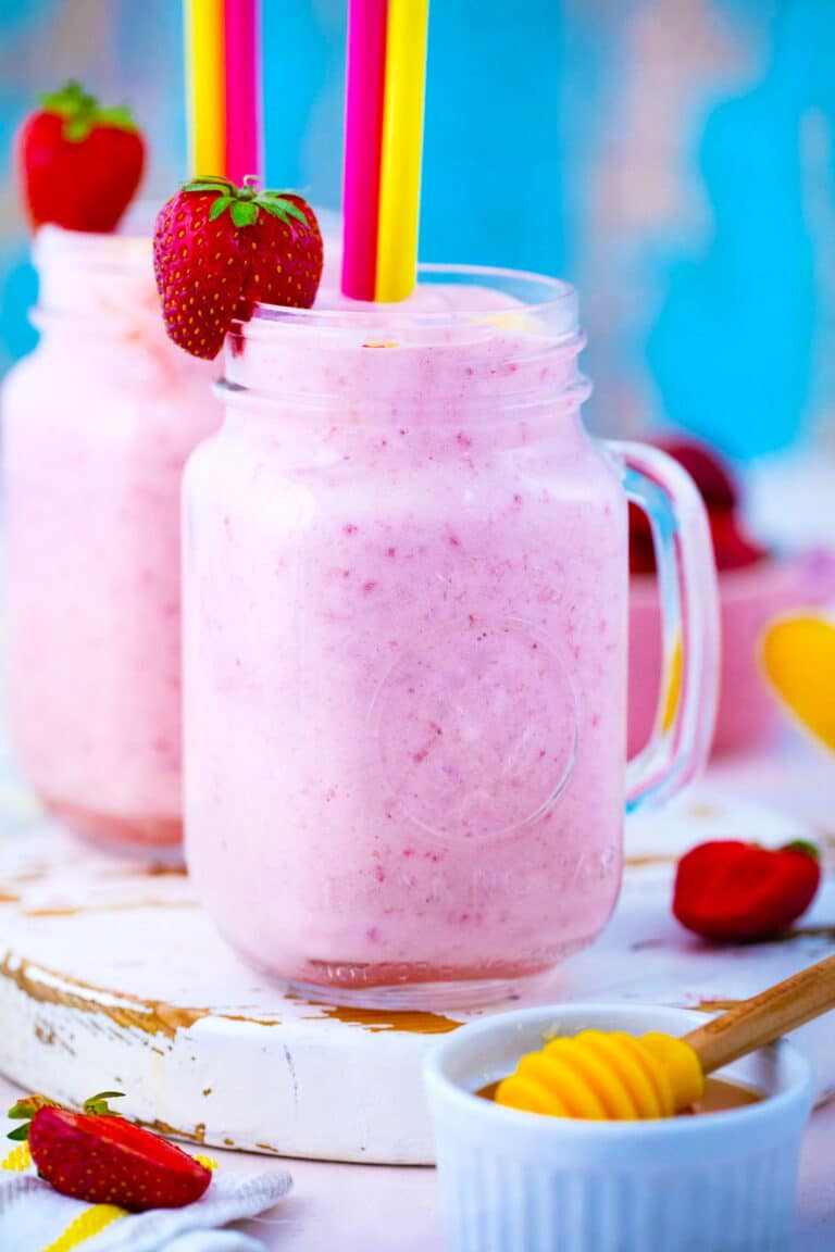 Two mason jars with strawberry banana smoothie.