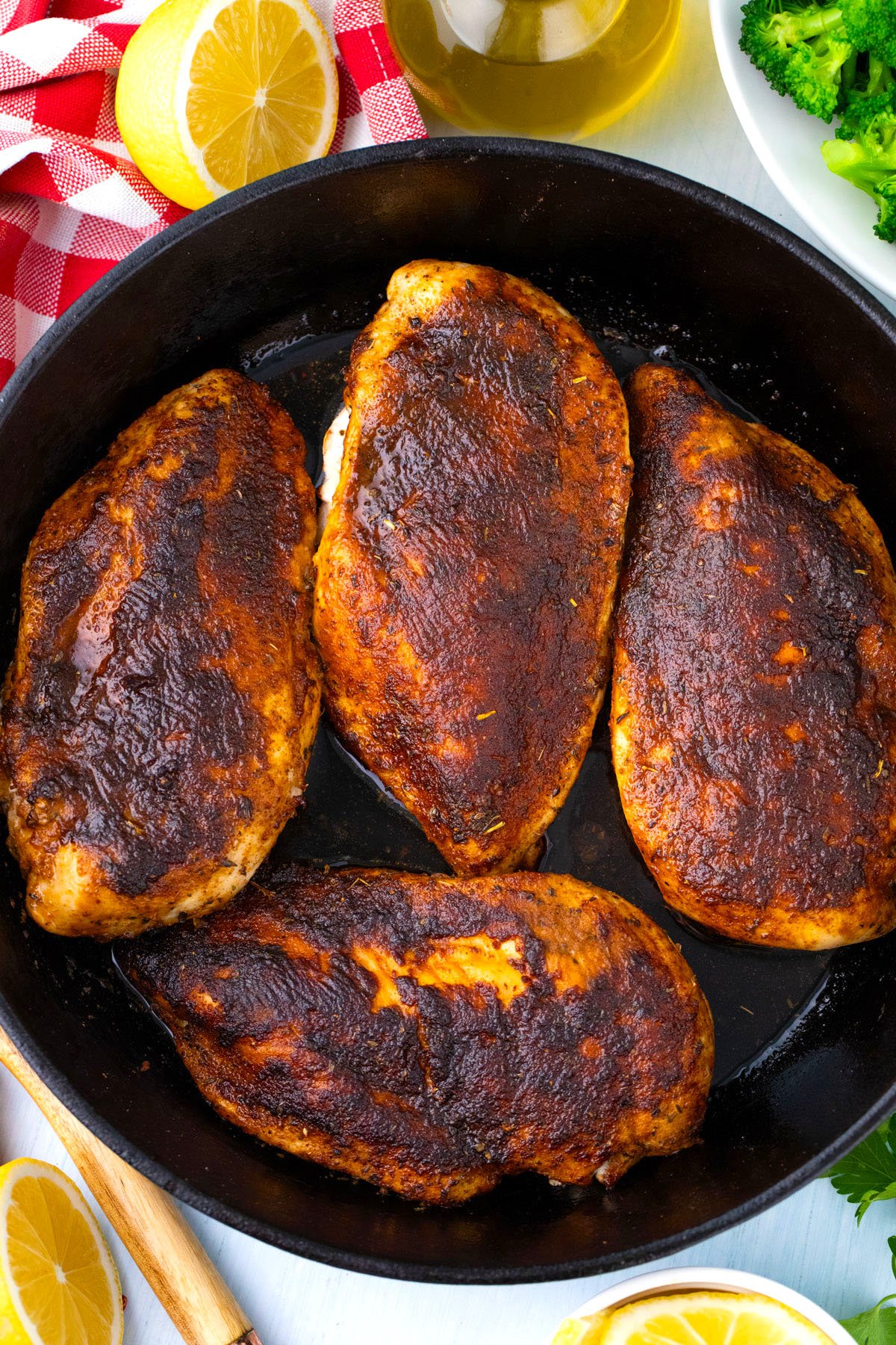 Blackened chicken breasts in a cast iron pan.
