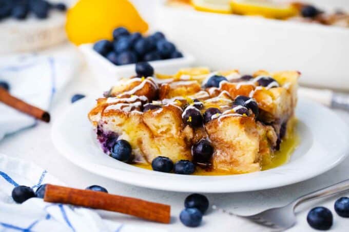 a slice of overnight blueberry french toast casserole served with fresh blueberries