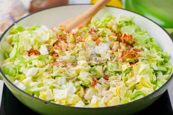 Cooking bacon fried cabbage in a skillet.