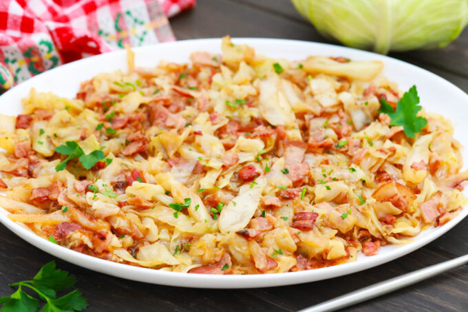 A serving plate with cabbage with bacon and onions.
