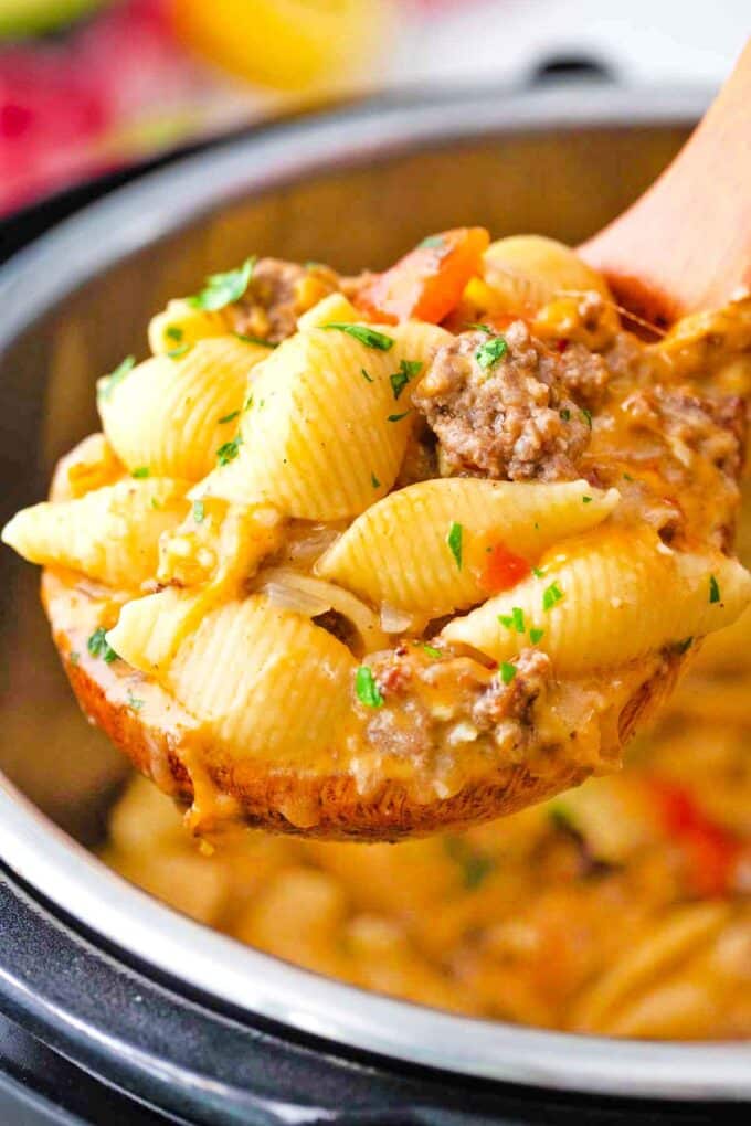 a ladle filled with juicy and cheese instant pot taco pasta