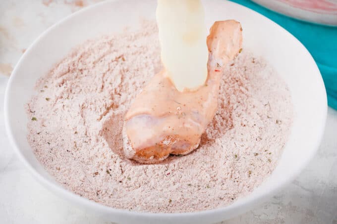 Coating marinated chicken drumstick on Ranch seasoning and flour mixture.