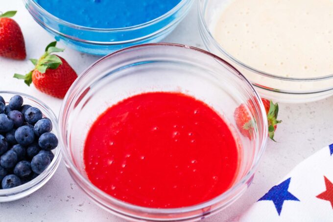 Bowls with red, white, and blue cake batter.