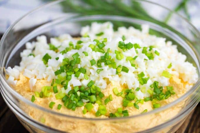 adding chopped egg whites and chives to deviled eggs dip