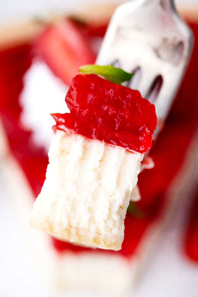 A forkful of layers strawberry cheesecake pie.