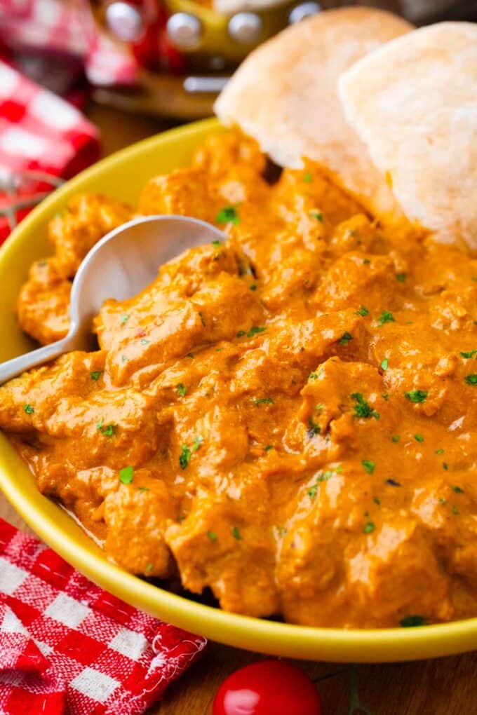 a plate of crockpot creamy butter chicken with naan