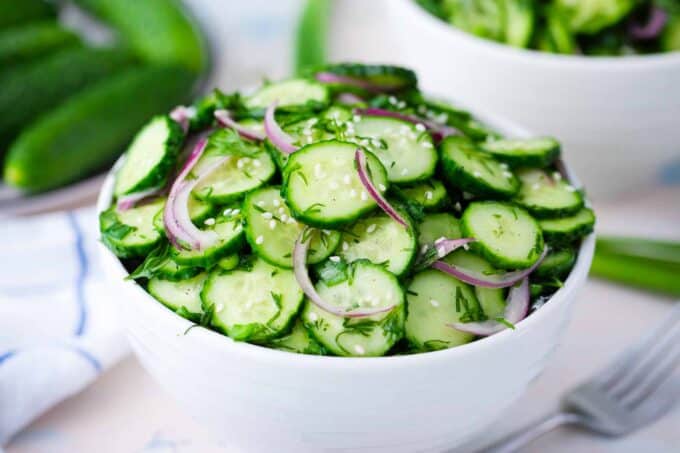 a bowl of crunchy cucumber salad with red onions