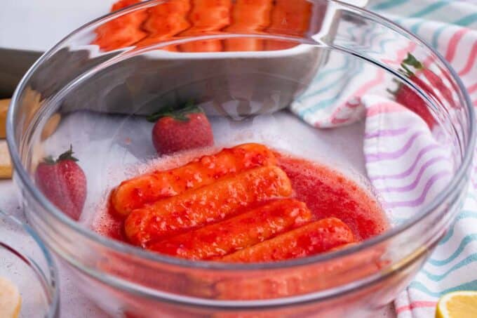 Dipping lady fingers in strawberry sauce.