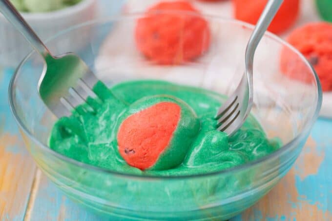 Dipping pink watermelon truffles in green candy melts.