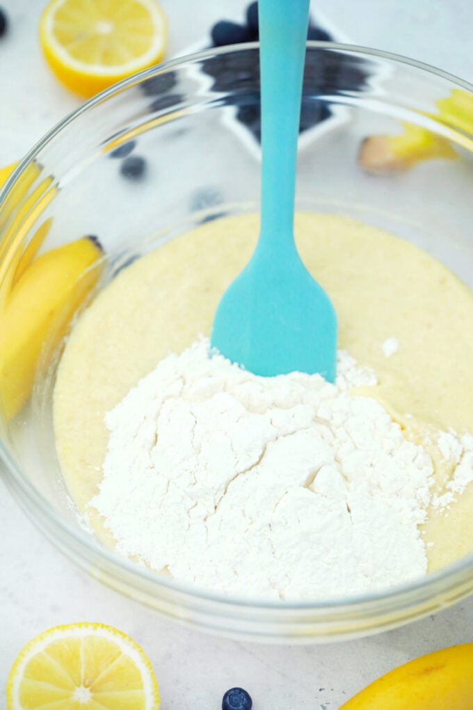 Stirring dry ingredients into wet ingredients.