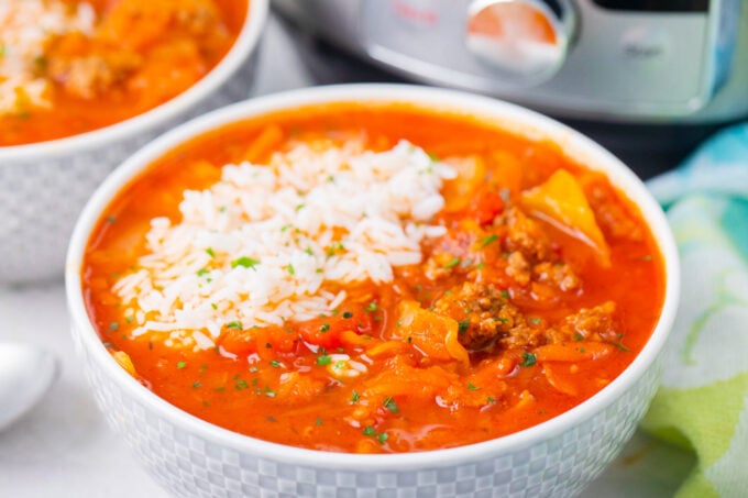 A bowl of instant pot cabbage roll soup served with a scoop of rice.