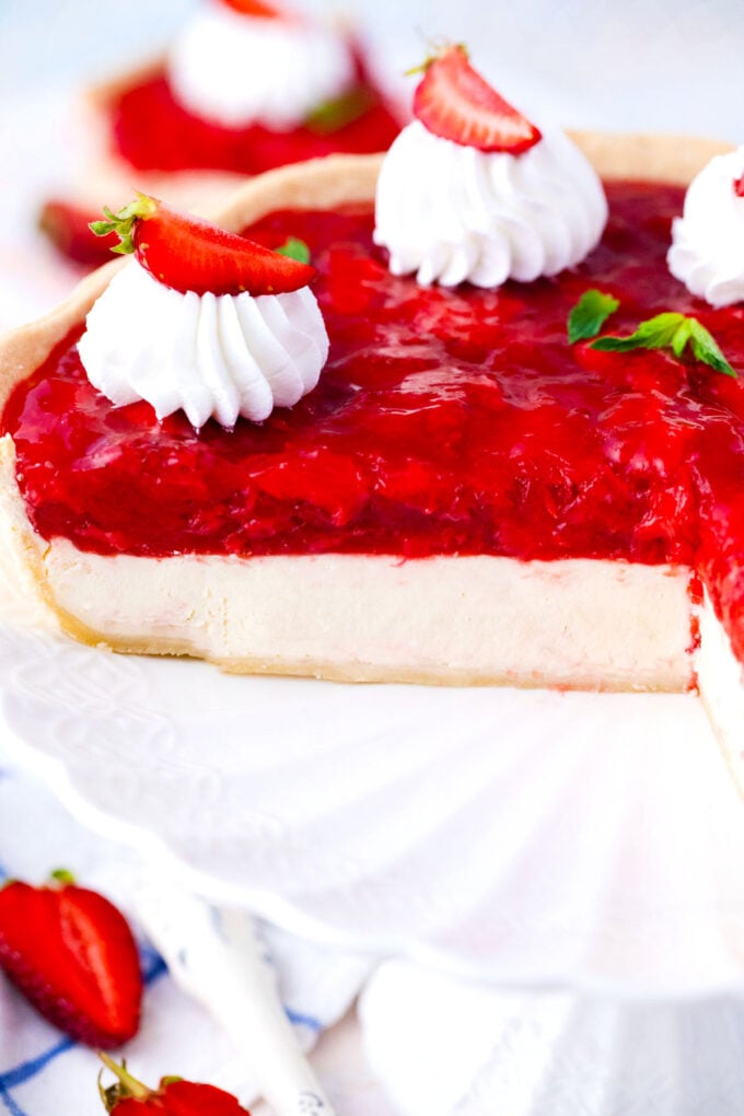 Sliced strawberry cheesecake pie in a pie dish.