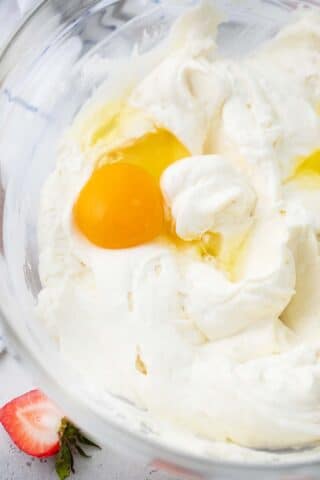 beating eggs into cream cheese