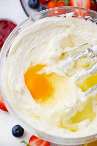 beating eggs into cream cheese