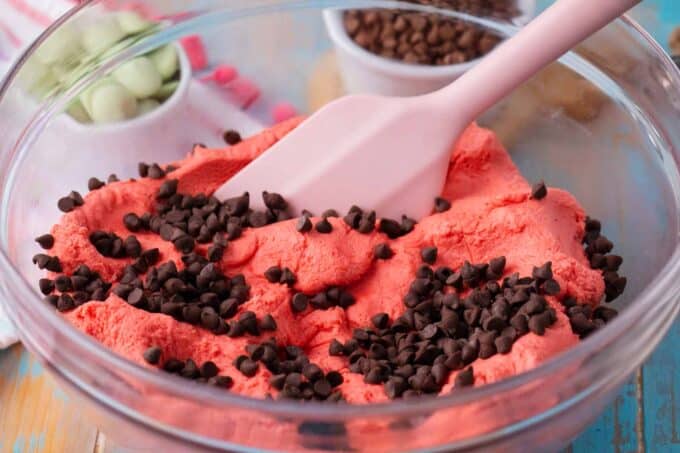 Stirring mini chocolate chips into pink watermelon truffle batter.