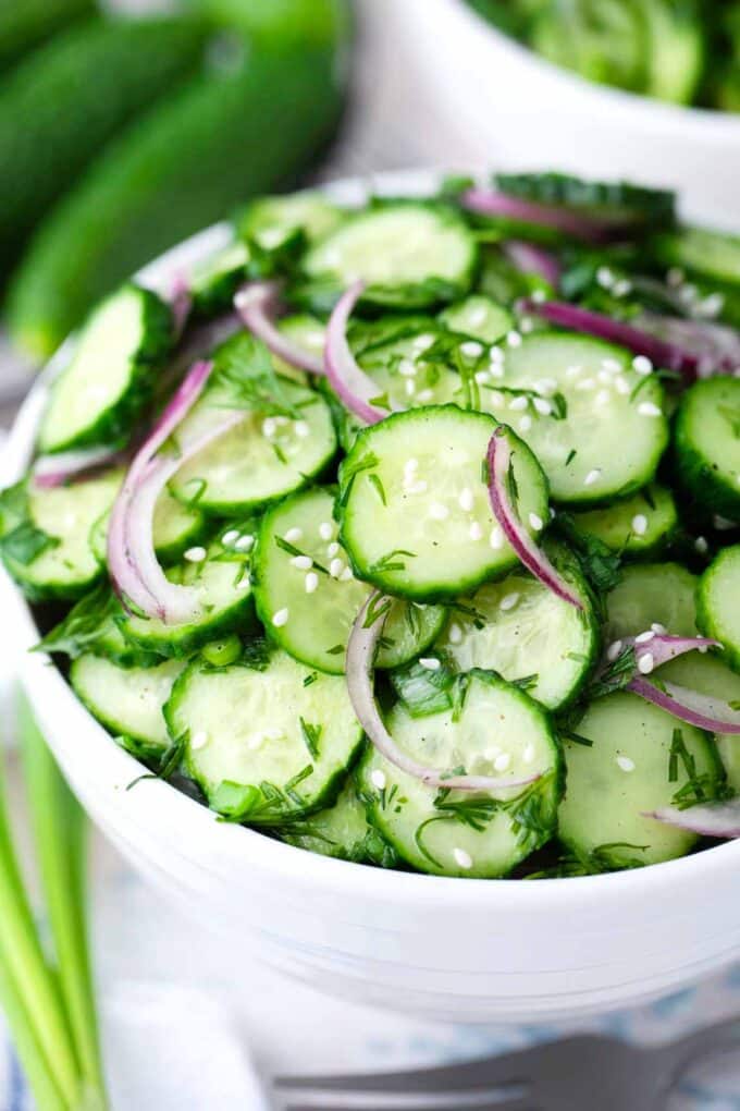 a bowl of vegan, fresh cucumber salad with onion and fresh herbs