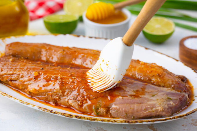 Brushing pork tenderloins with honey paste.