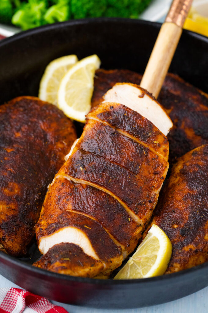 Slices blackened chicken on a serving spatula.