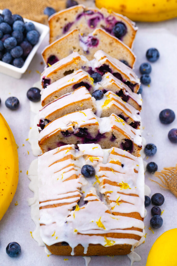Sliced blueberry banana bread topped with a sugar glaze.