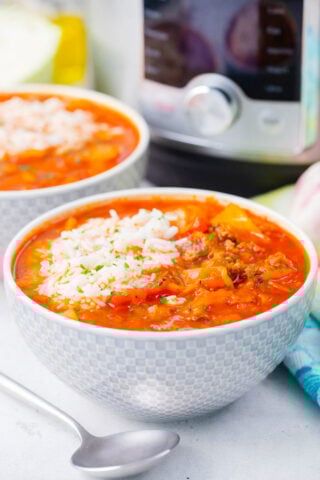 Bowls of instant pot cabbage roll soup next to the pressure cooker.
