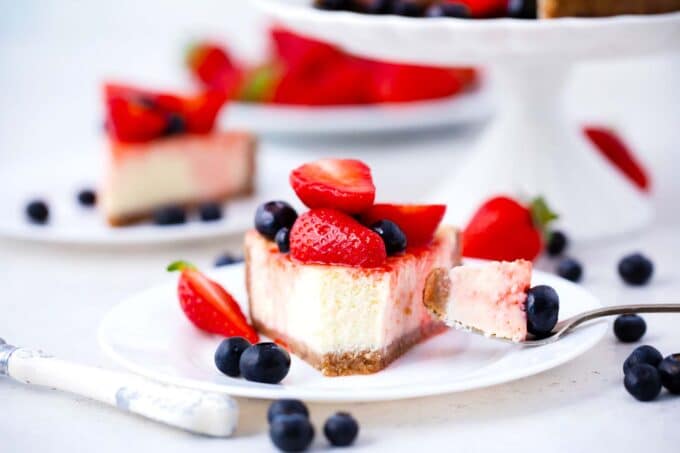 a slice of instant pot cheesecake topped with blueberries and strawberries
