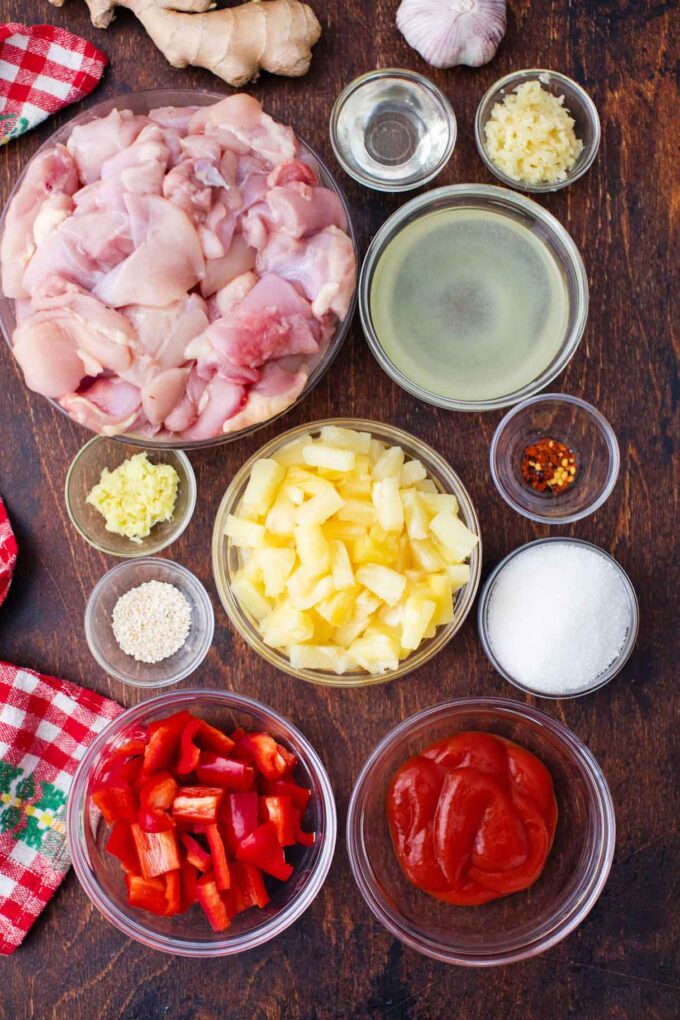 overhead shot of instant pot sweet and sour chicken ingredients in bowls on a wooden table